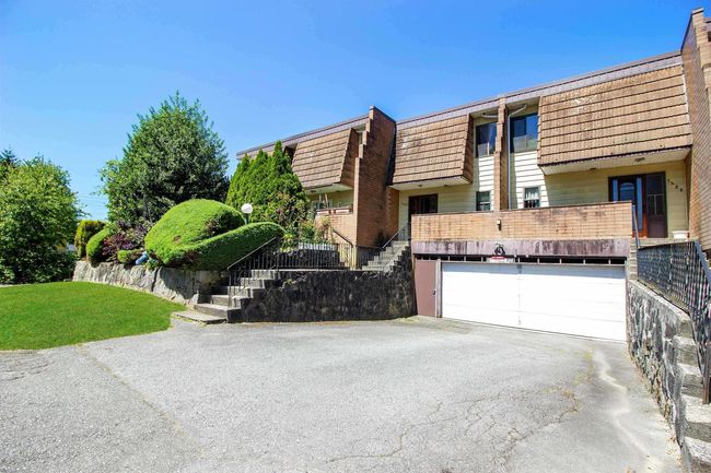View of front of home featuring aphalt driveway, mansard roof, stairway, a front yard, and a garage | Image 27