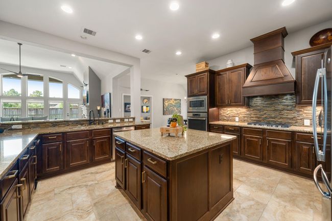 Any chef's dream, this stunning kitchen is perfect for everyday life as well as entertaining family and friends! Extra large kitchen counter is perfect for conversation or that much needed space to lay out your party spread for everyone to enjoy! Large windows provide lovely views of your backyard and plenty of natural lighting throughout the day. | Image 13
