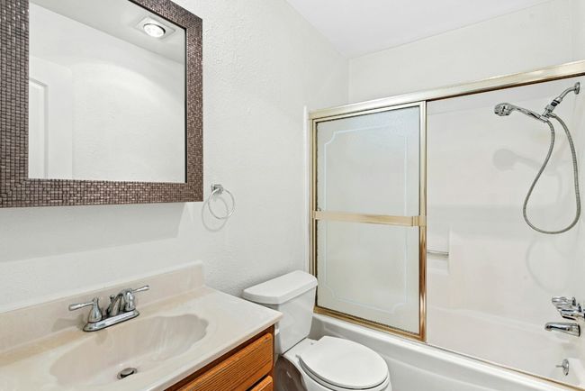Bathroom featuring vanity and enclosed tub / shower combo | Image 18
