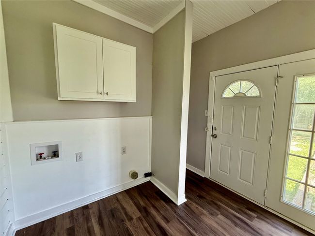 Laundry area featuring washer hookup, cabinet space, dark wood-style floors, and hookup for an electric dryer | Image 14