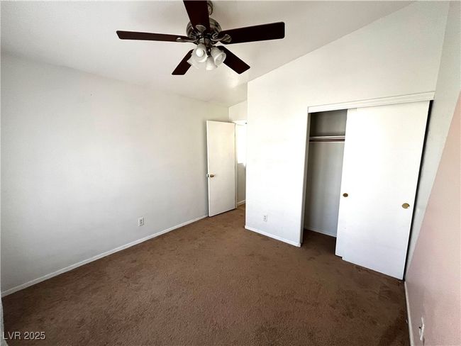 Unfurnished bedroom featuring vaulted ceiling, carpet flooring, baseboards, a ceiling fan, and a closet | Image 16