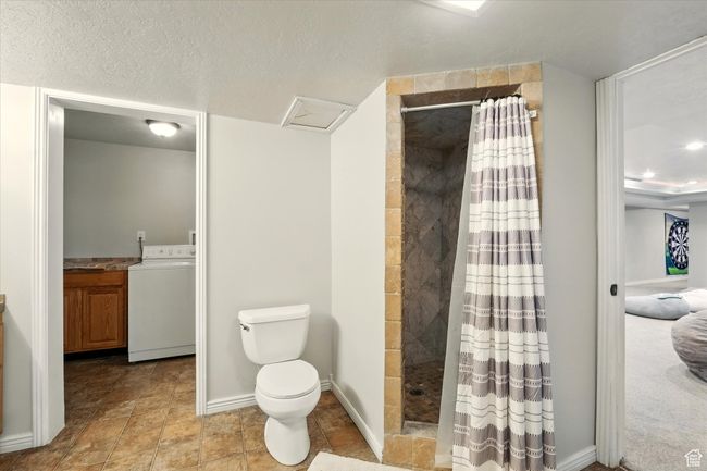 Bathroom featuring washer / dryer, tiled shower, and vanity | Image 37