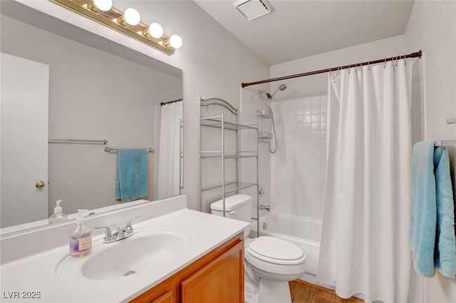 Full bathroom with toilet, shower / bathtub combination with curtain, and vanity | Image 19