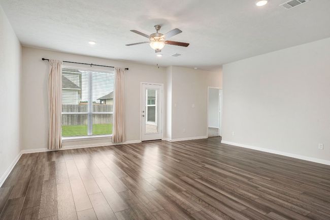 Spacious main living area with upgraded fan, luxury vinyl flooring, and backyard access | Image 10