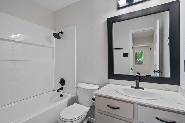 Full bathroom featuring vanity, bathing tub / shower combination, and a textured wall | Image 18