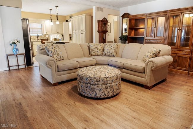 Living area featuring light wood finished floors and visible vents | Image 8