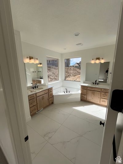 Bathroom featuring vanity and a bath | Image 3