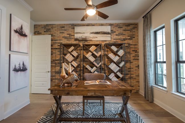 Office area with brick wall, ceiling fan, wood finished floors, baseboards, and crown molding | Image 8