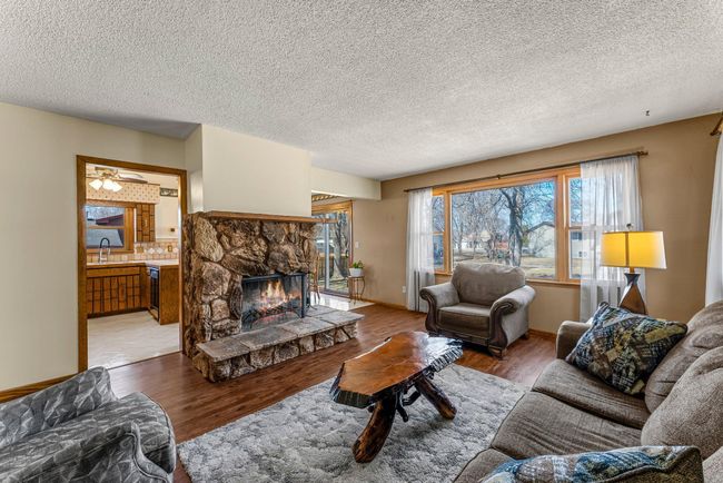 Large picture windows frame beautiful backyard views while allowing natural light to pour in. Stylish and durable LVP flooring enhances the warmth of the space. | Image 5