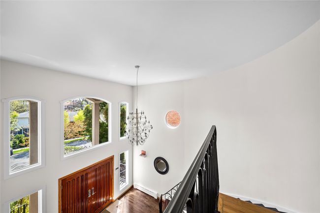 Entrance foyer with a high ceiling, dark wood-style flooring, a wealth of natural light, and a baseboard radiator | Image 8