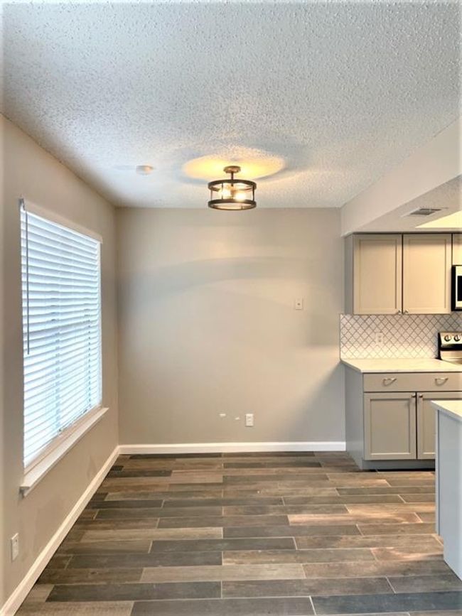 Unfurnished dining area with dark wood-type flooring, a textured ceiling, and baseboards | Image 5