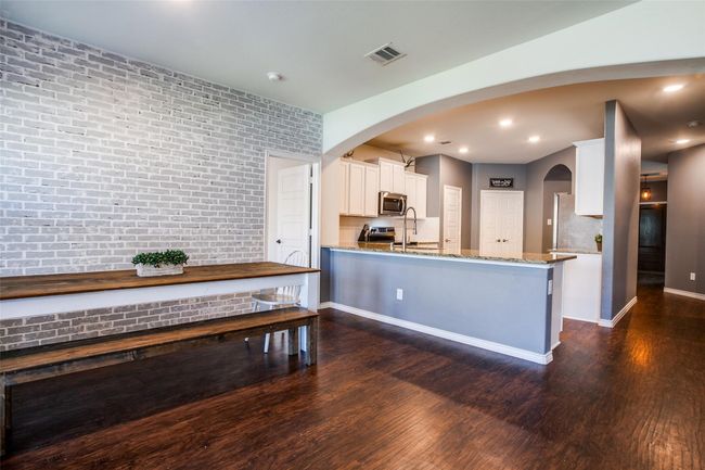 Kitchen with white cabinets, stainless steel appliances, light stone countertops, and dark hardwood / wood-style flooring | Image 7