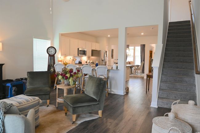 Living area featuring a towering ceiling, stairs, dark wood-style flooring, and recessed lighting | Image 13