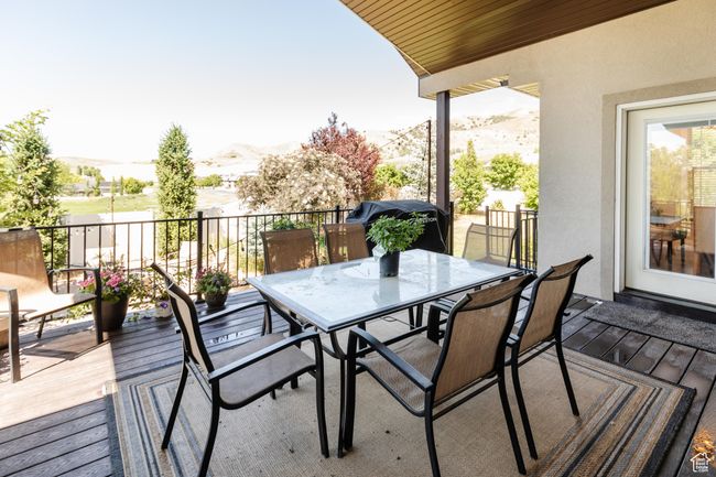 Wooden terrace with a mountain view, outdoor dining space, and a grill | Image 43