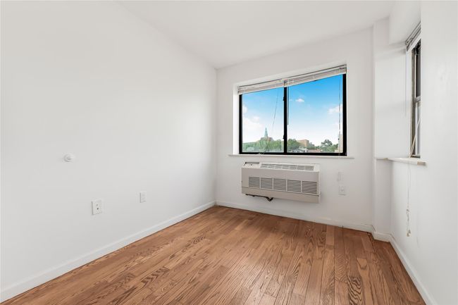 Empty room featuring a wall mounted air conditioner and wood finished floors | Image 15
