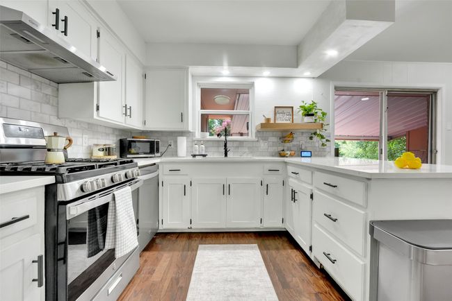 Kitchen with ventilation hood, stainless steel appliances, open shelves, healthy amount of natural light, and recessed lighting | Image 25