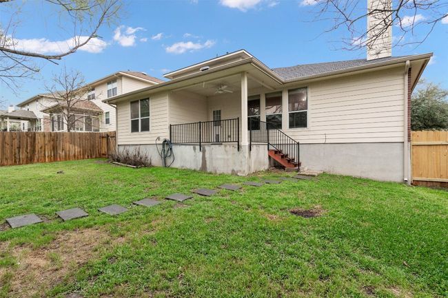 Back of house featuring a chimney, a ceiling fan, fence, and a yard | Image 22