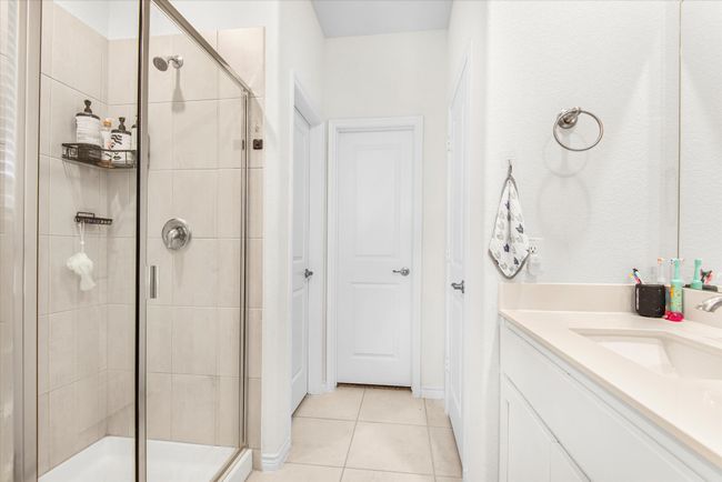 Full bath featuring a shower stall, vanity, and tile patterned floors | Image 17