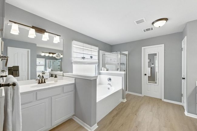 Bathroom with wood finished floors, a shower stall, a garden tub, and vanity | Image 19