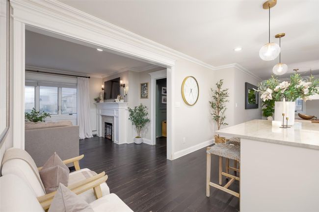 Living room with baseboards, a fireplace, dark wood-style floors, and ornamental molding | Image 15