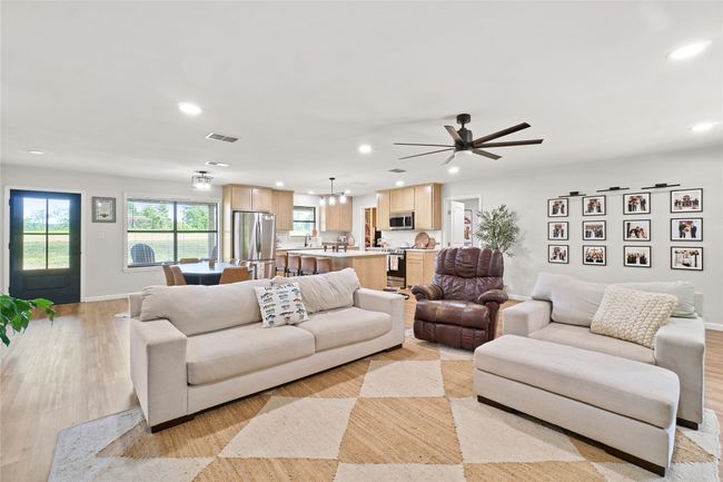 Living area with recessed lighting, a ceiling fan, a chandelier, and light wood finished floors | Image 11