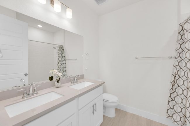 Bathroom with baseboards, a sink, toilet, and double vanity | Image 27