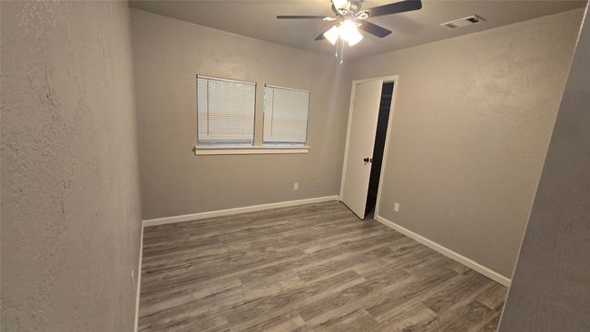 Unfurnished room featuring ceiling fan, wood finished floors, and a textured wall | Image 12