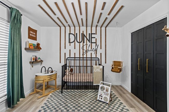 Bedroom featuring a nursery area, light floors, and dual closets. | Image 19