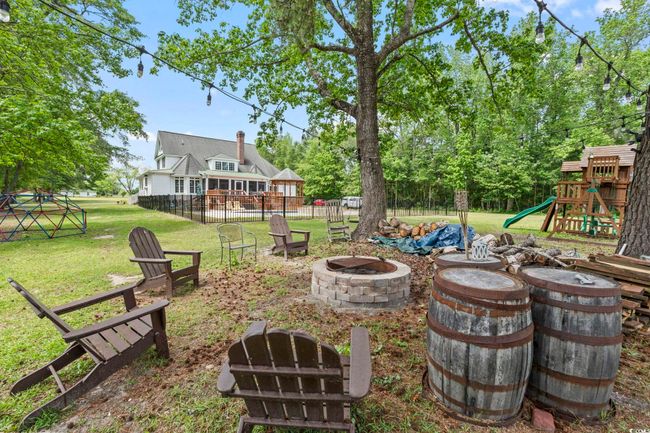 View of yard with an outdoor fire pit and a playground | Image 34