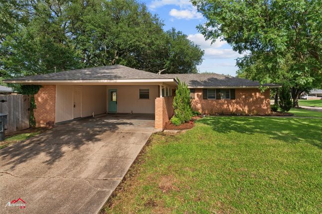 Single story home featuring brick siding, driveway, and a carport | Image 21