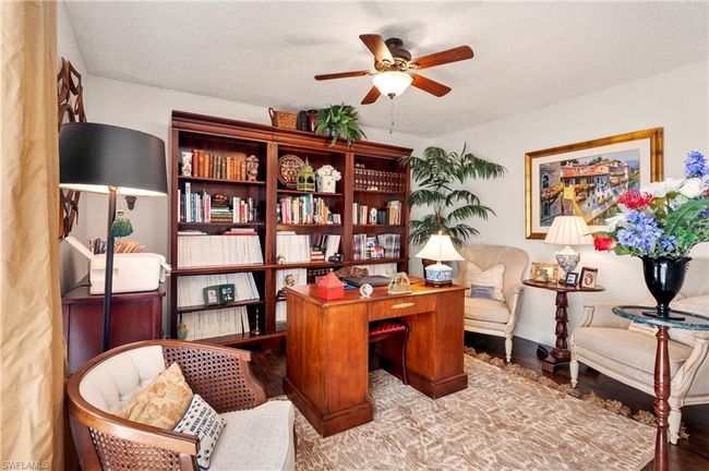Office space featuring a ceiling fan, wood finished floors, and a textured ceiling | Image 20