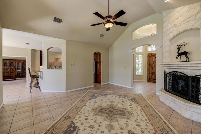 arched walkways lead into the cozy living room with wood-burning fireplace. Adjoining chef's kitchen makes entertaining a breeze. | Image 6
