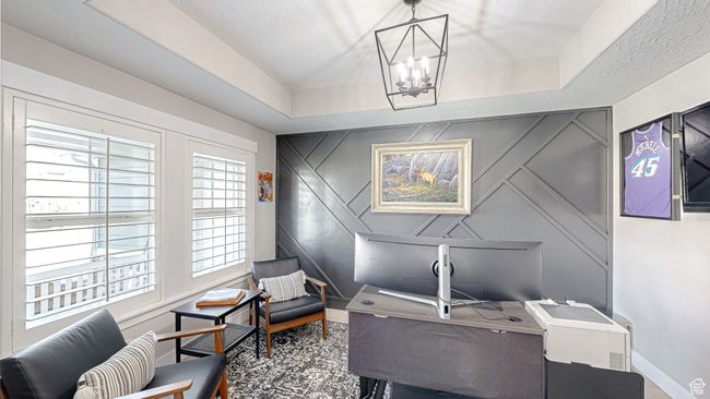 Home office with baseboards, a notable chandelier, an accent wall, and a raised ceiling | Image 12