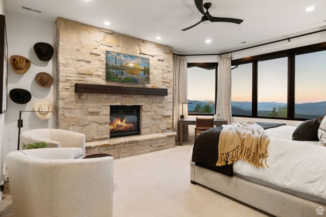 Carpeted bedroom with a stone fireplace, recessed lighting, and ceiling fan | Image 5