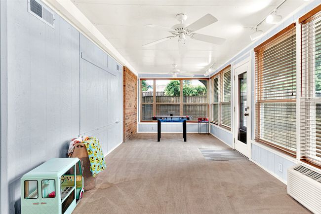 Unfurnished sunroom featuring a ceiling fan, rail lighting, and a wall unit AC | Image 12