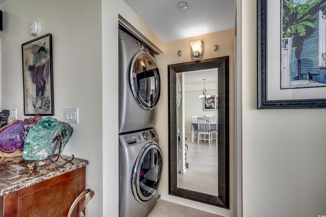 Washroom featuring stacked washer and clothes dryer and a chandelier | Image 13