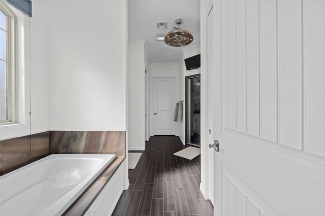 Full bathroom featuring a bath, wood finished floors, and ornamental molding | Image 11