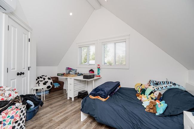 Bedroom featuring lofted ceiling with beams, recessed lighting, a wall mounted air conditioner, and wood finished floors | Image 22