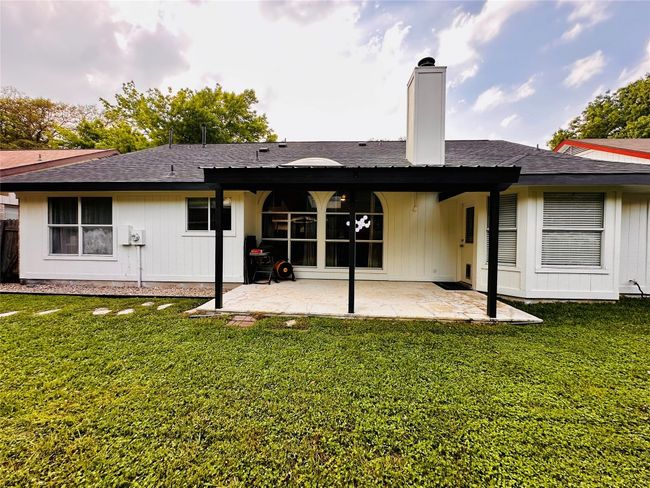 Back of house featuring a chimney, a patio, a lawn, and roof with shingles | Image 25