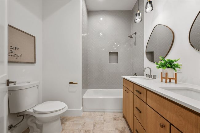 Bathroom with toilet, baseboards, double vanity, and tub / shower combination | Image 15