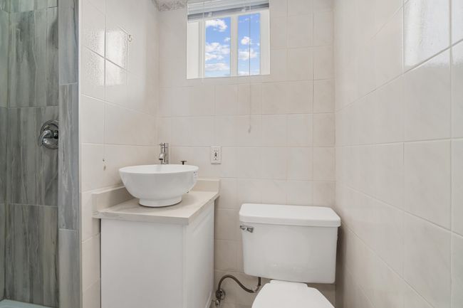 Full bath featuring tile walls, tiled shower, vanity, and toilet | Image 31