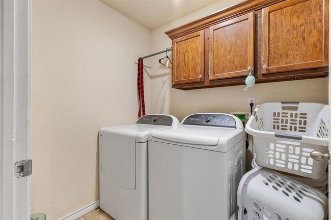 Laundry area with cabinets and washing machine and clothes dryer | Image 8