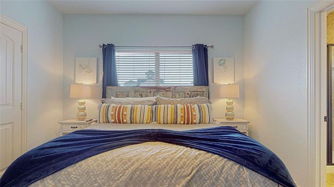 Spacious primary bedroom filled with natural light, offering ample closet space and an ensuite bathroom featuring a walk-in shower. | Image 19