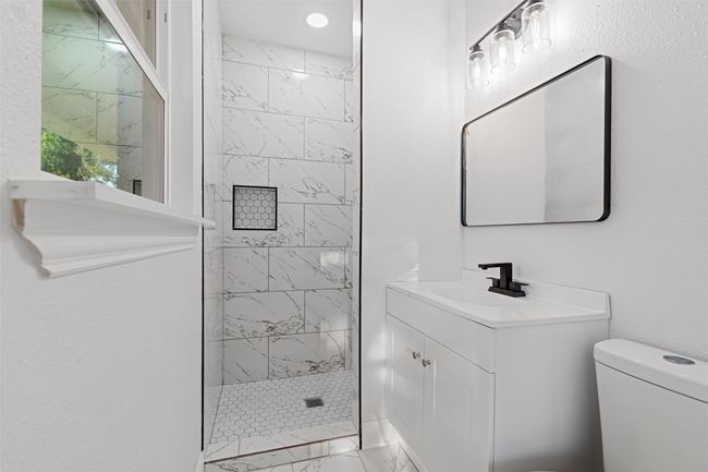 Bathroom with vanity, tiled shower, and toilet | Image 20