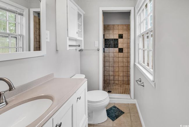 Full bath featuring vanity, a tile shower, and tile patterned floors | Image 20