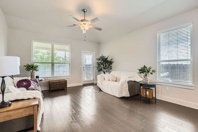 Living room featuring a ceiling fan and dark wood-type flooring | Image 4