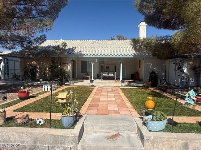 View of front facade with a tile roof, a chimney, a porch, and stucco siding | Image 63