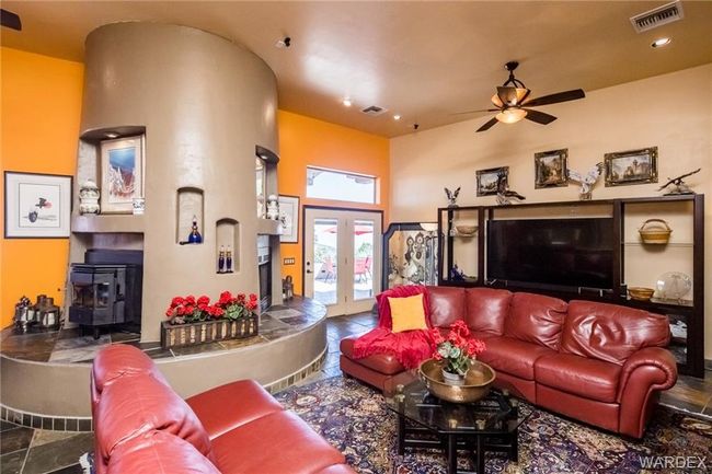 Living room featuring ceiling fan, a wood stove, french doors, recessed lighting, and stone tile flooring | Image 64
