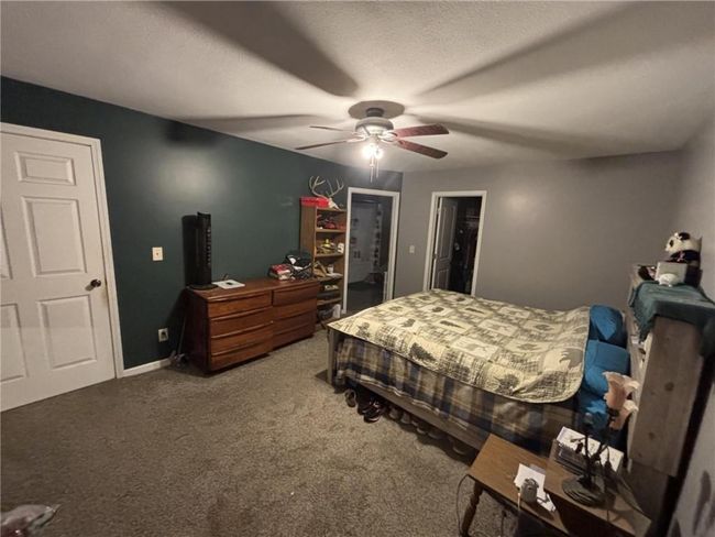 Bedroom with carpet floors, ceiling fan, and a spacious closet | Image 34