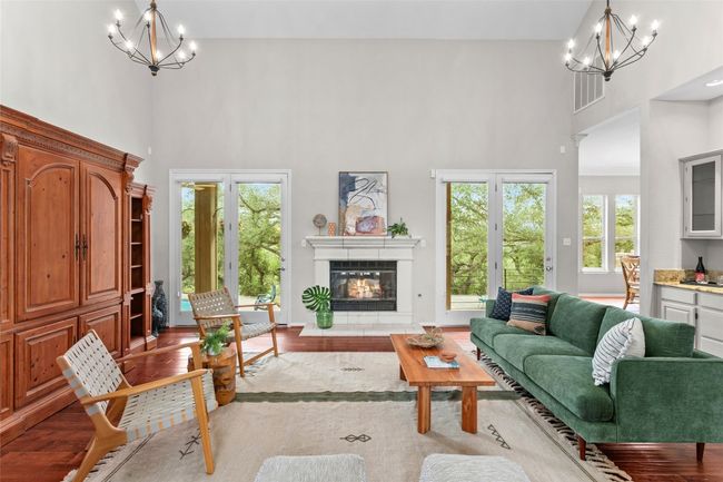 This great room with towering ceilings and a cozy fireplace is the hub of the home | Image 4